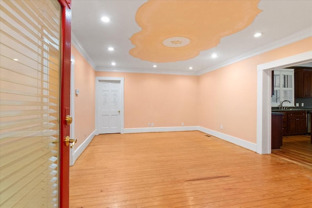 spare room with sink, crown molding, and light hardwood / wood-style flooring