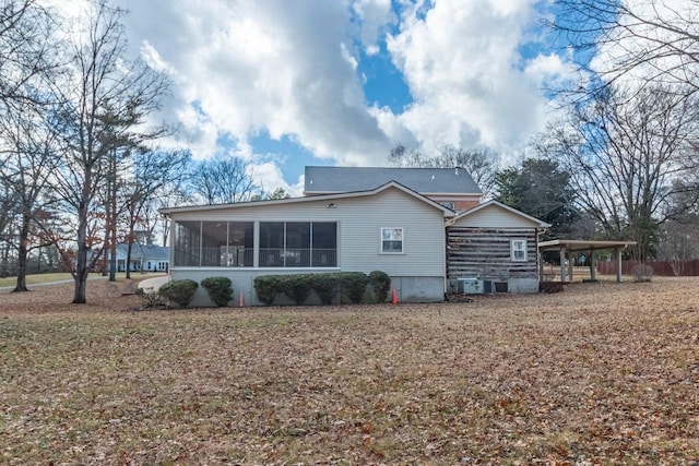 rear view of house with central AC, a sunroom, and a carport