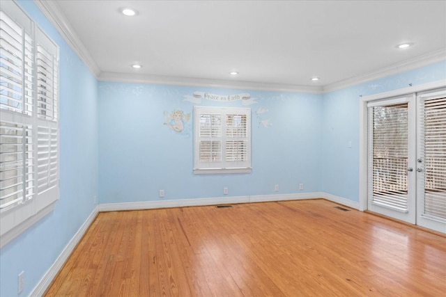 spare room featuring light hardwood / wood-style flooring, ornamental molding, and french doors