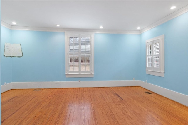 empty room featuring ornamental molding and light wood-type flooring