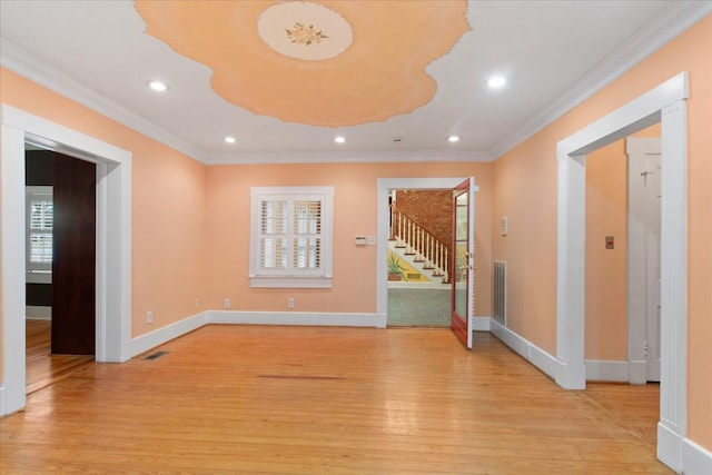 empty room featuring crown molding and light hardwood / wood-style floors