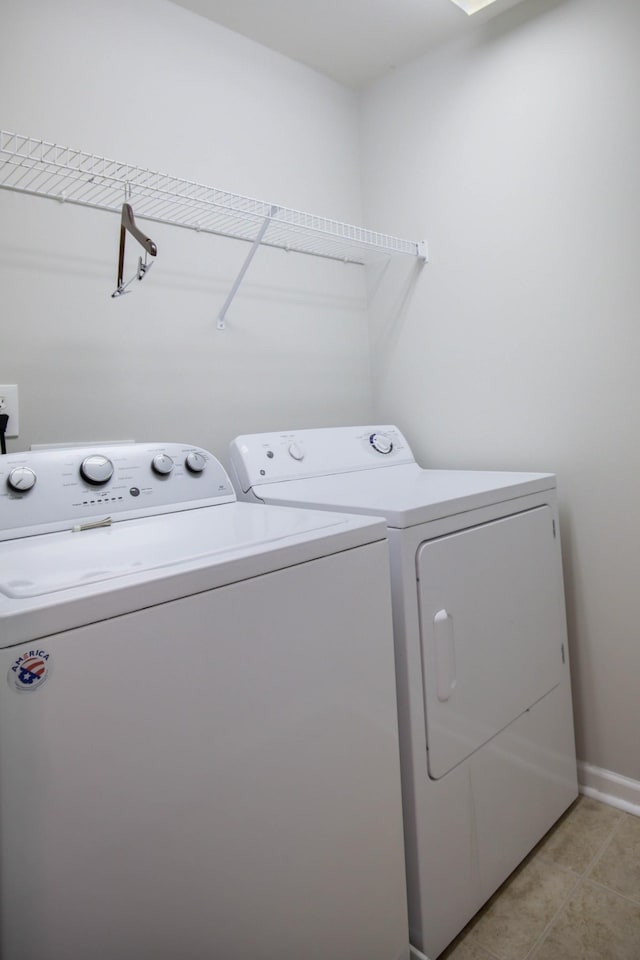 washroom with washer and clothes dryer and light tile patterned floors