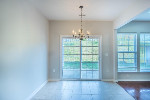 entryway with light tile patterned flooring and a chandelier