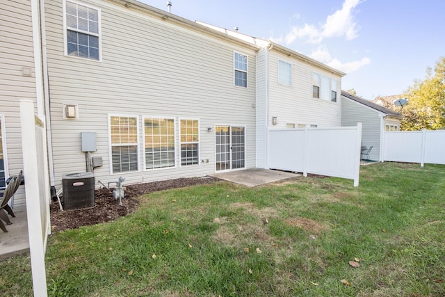 rear view of house featuring a patio, cooling unit, and a lawn