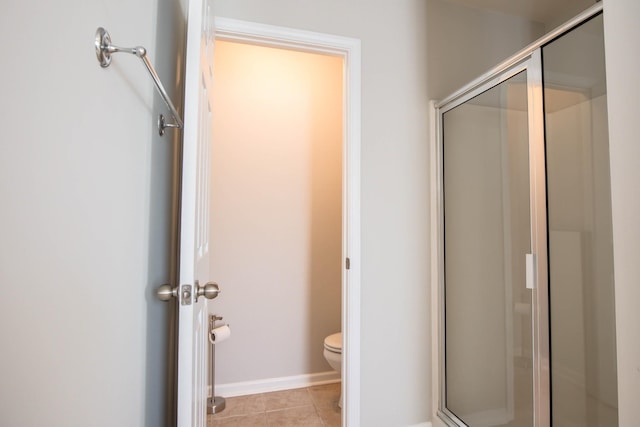 bathroom with toilet, tile patterned flooring, and walk in shower