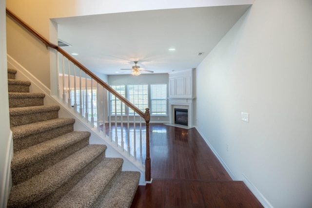 staircase featuring hardwood / wood-style flooring and ceiling fan