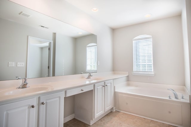 bathroom with tile patterned flooring, vanity, and a washtub