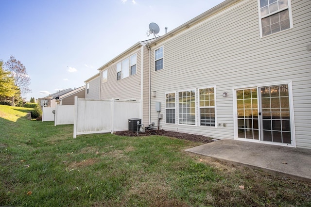 back of property with a lawn, central AC unit, and a patio area