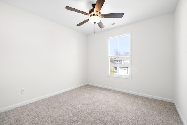 carpeted empty room featuring visible vents, baseboards, and ceiling fan