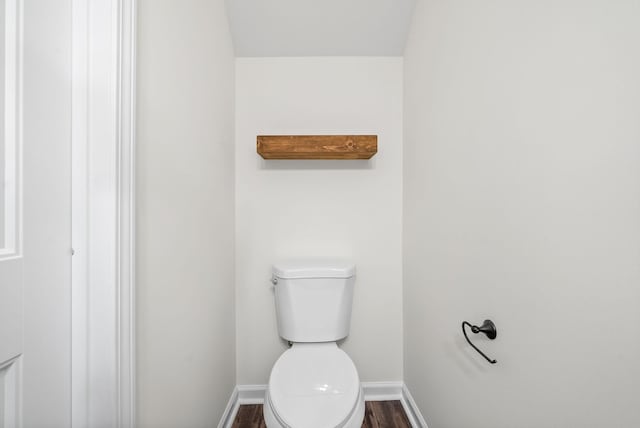 bathroom with toilet, baseboards, and wood finished floors