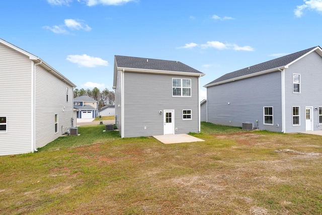 back of property with a yard, central air condition unit, and a patio