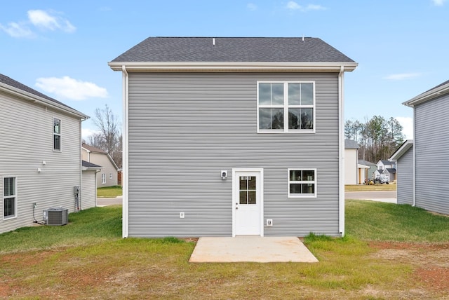 rear view of house with a patio, a lawn, and central AC