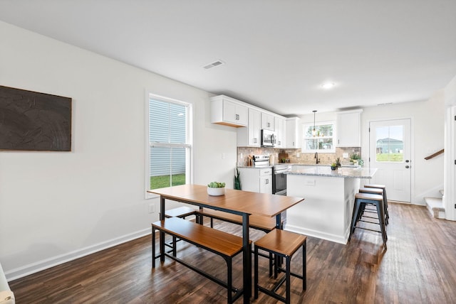 dining room featuring visible vents, baseboards, dark wood-type flooring, and stairway