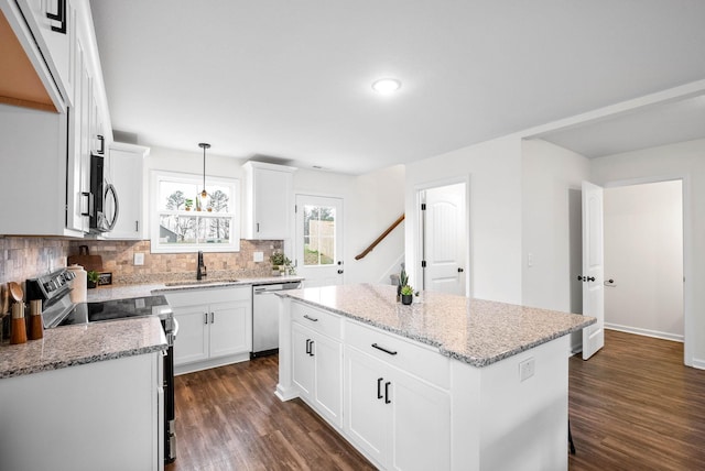 kitchen featuring a center island, dark wood-style floors, appliances with stainless steel finishes, and a sink