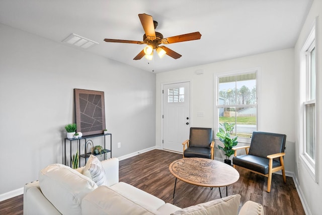 living area with visible vents, baseboards, a ceiling fan, and wood finished floors