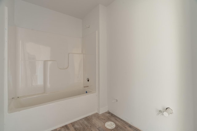 bathroom with hardwood / wood-style floors and  shower combination