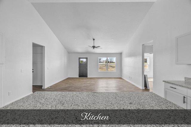 unfurnished living room featuring high vaulted ceiling, ceiling fan, baseboards, and wood finished floors