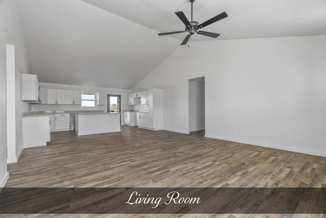 unfurnished living room featuring baseboards, high vaulted ceiling, dark wood finished floors, and a ceiling fan