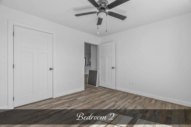 unfurnished bedroom featuring a ceiling fan, baseboards, and wood finished floors