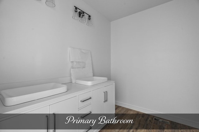 bathroom featuring vanity, baseboards, and wood finished floors