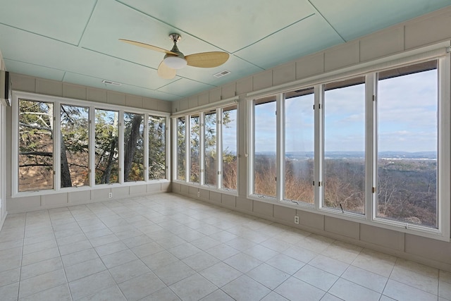 unfurnished sunroom featuring ceiling fan