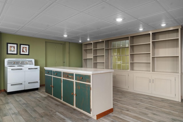 kitchen featuring a center island, stove, built in features, and washer / clothes dryer