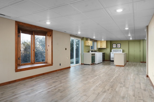 unfurnished living room with separate washer and dryer and light hardwood / wood-style flooring