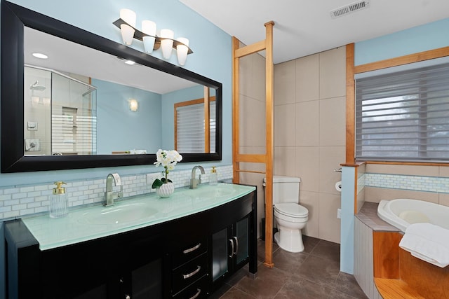 full bathroom featuring tile patterned floors, vanity, shower with separate bathtub, and toilet