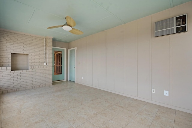 tiled empty room with ceiling fan and brick wall