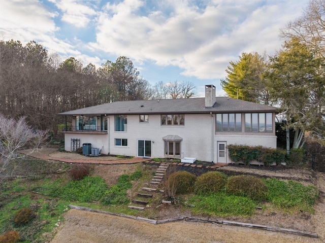 back of property featuring a sunroom and central AC