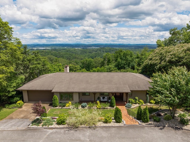 540 N Crest Ct, Chattanooga, TN 37404 - single story home with a wooded view, concrete driveway, an attached garage, a chimney, and a shingled roof