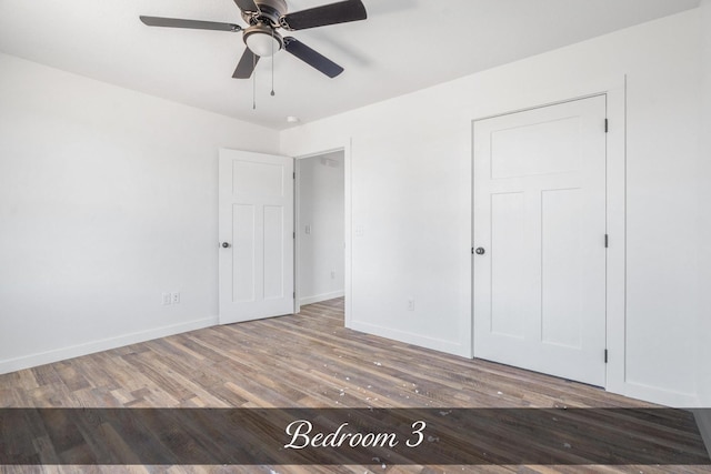 unfurnished bedroom with wood finished floors, a ceiling fan, and baseboards