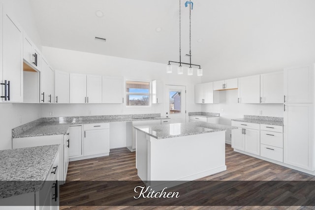 kitchen featuring white cabinets, dark wood finished floors, light stone counters, high vaulted ceiling, and pendant lighting