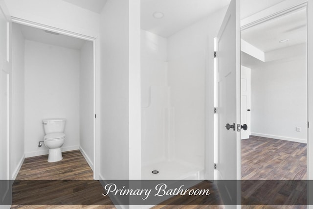 full bathroom with baseboards, a shower stall, toilet, and wood finished floors