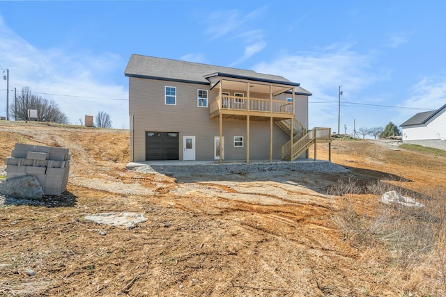 back of property featuring an attached garage, stairway, and a wooden deck