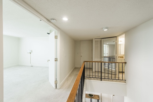 corridor with carpet and a textured ceiling