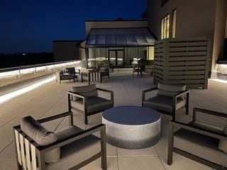 patio at twilight with a balcony and an outdoor hangout area