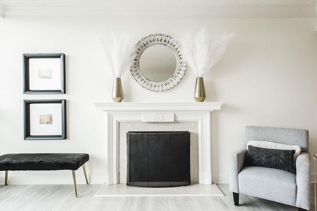 living area with hardwood / wood-style floors and ornamental molding