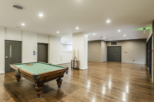 playroom with elevator, wood-type flooring, billiards, and brick wall