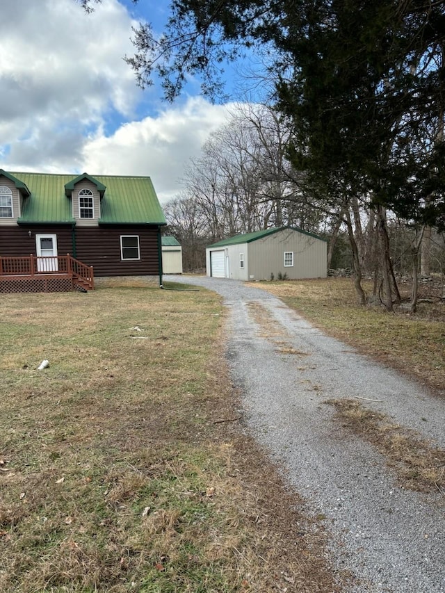 view of front facade with a front yard, an outdoor structure, and a garage