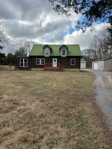 view of front of house with an outbuilding, a front lawn, and a garage