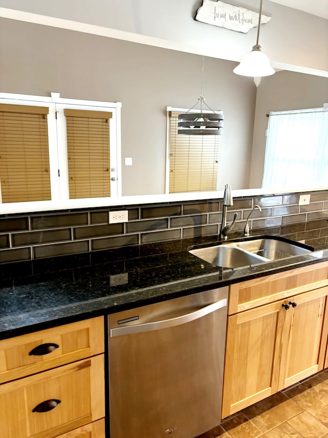 kitchen with sink, stainless steel dishwasher, backsplash, dark stone counters, and decorative light fixtures