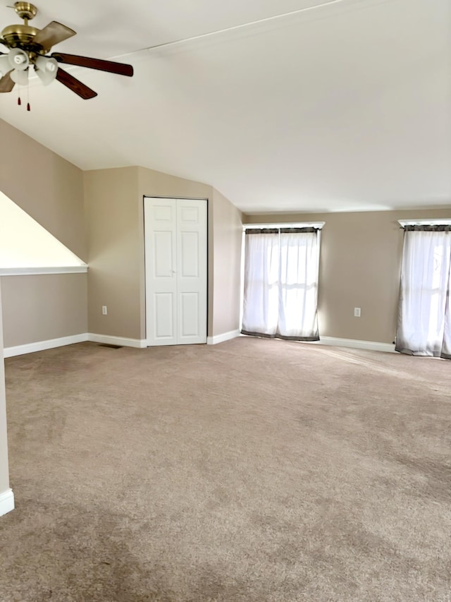 bonus room featuring ceiling fan, carpet, a healthy amount of sunlight, and vaulted ceiling