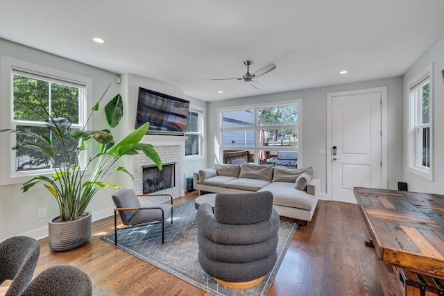 living room with ceiling fan, a wealth of natural light, and a brick fireplace