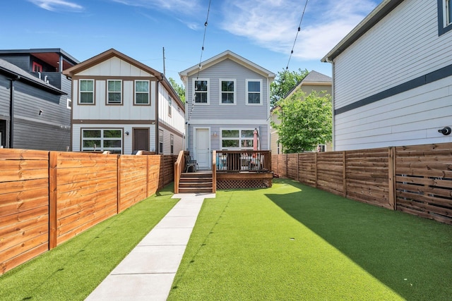 back of property with a lawn and a wooden deck