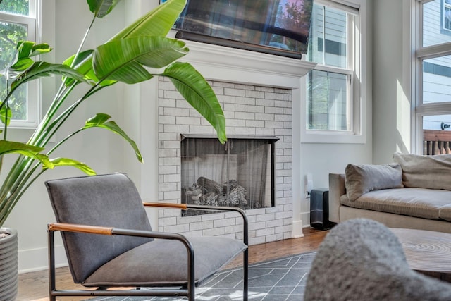 sitting room featuring dark hardwood / wood-style floors and a brick fireplace