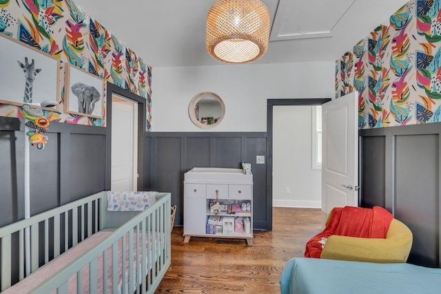 bedroom featuring dark hardwood / wood-style flooring and a nursery area