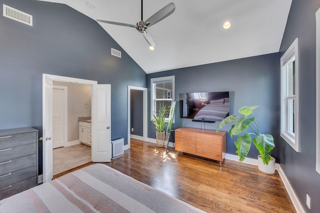 bedroom with multiple windows, light hardwood / wood-style flooring, ensuite bath, and ceiling fan