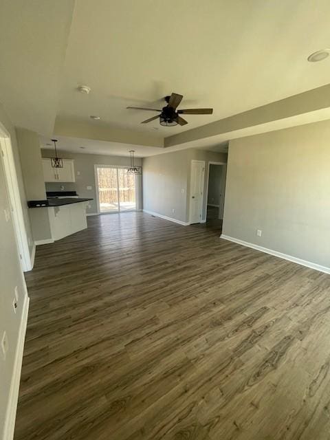 unfurnished living room with dark hardwood / wood-style floors and ceiling fan