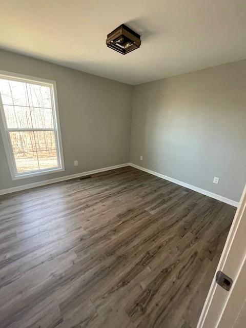 spare room with dark wood-type flooring